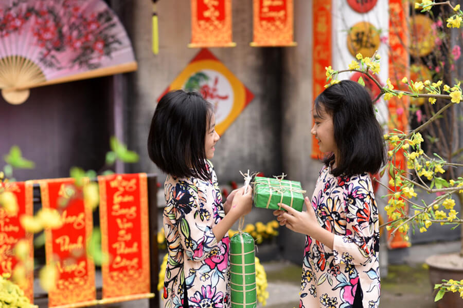 Girls with Banh Chung - Banh Tet in first days of new year
